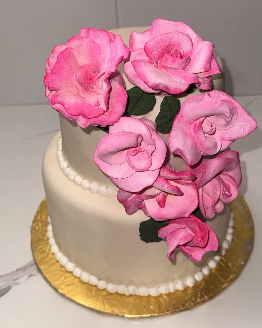 Two-tier ivory cake with pink sugar roses