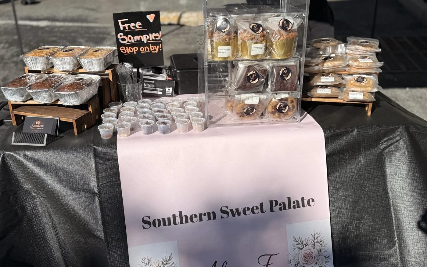 The Southern Sweet Palate market table with pound cakes, cookies, and free samples